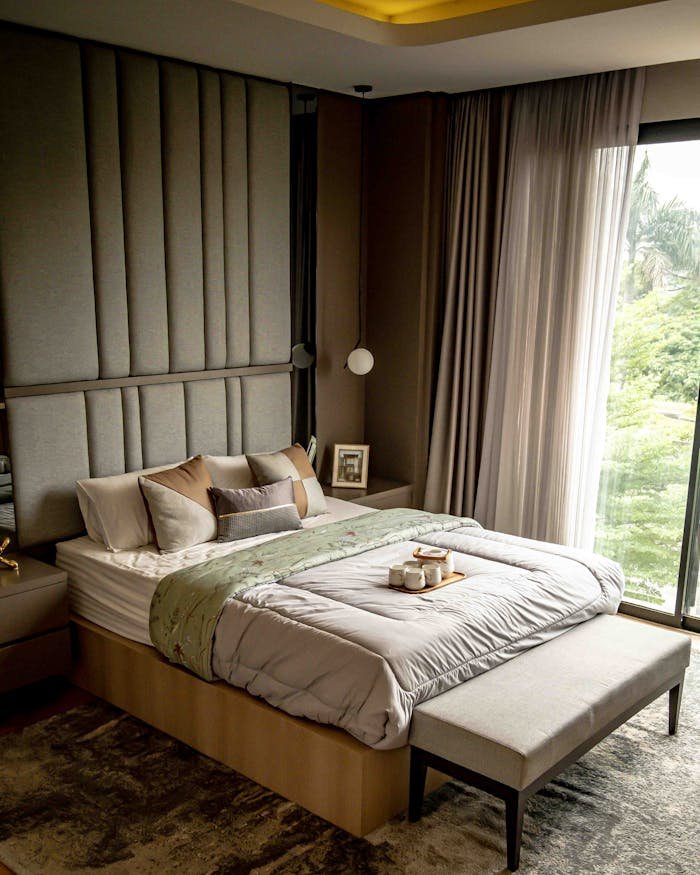 Cozy and stylish bedroom with elegant decor and a nature view from the window.