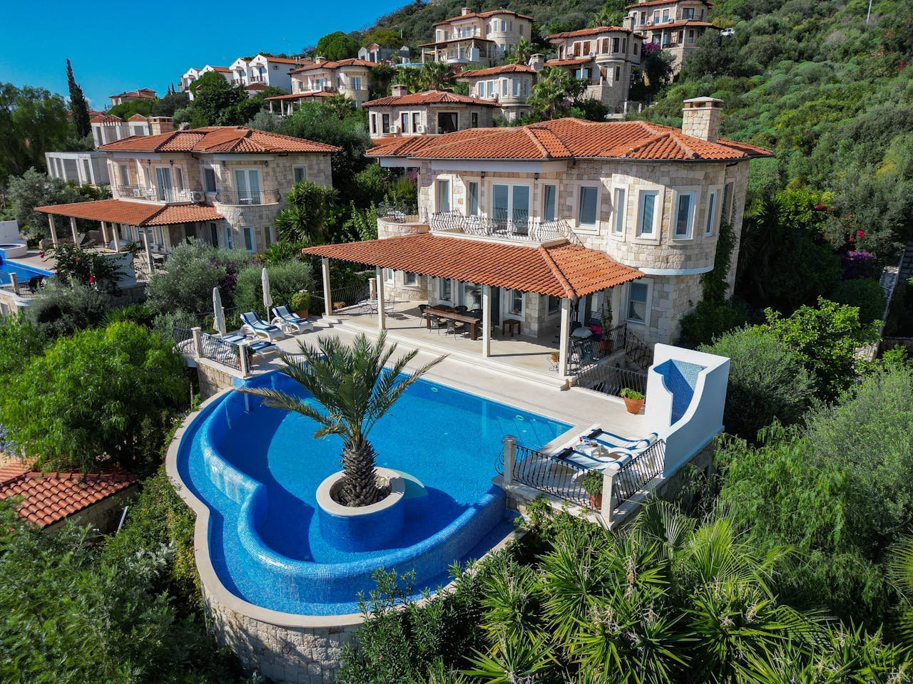 Elegant villa with stunning infinity pool surrounded by lush greenery and scenic views.